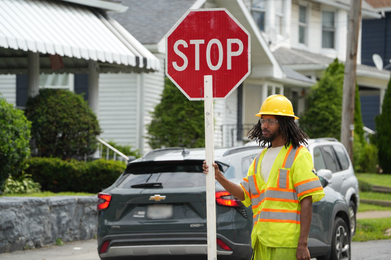 Traffic Regulators flagger holding a stop sign beside a work-zone vehicle