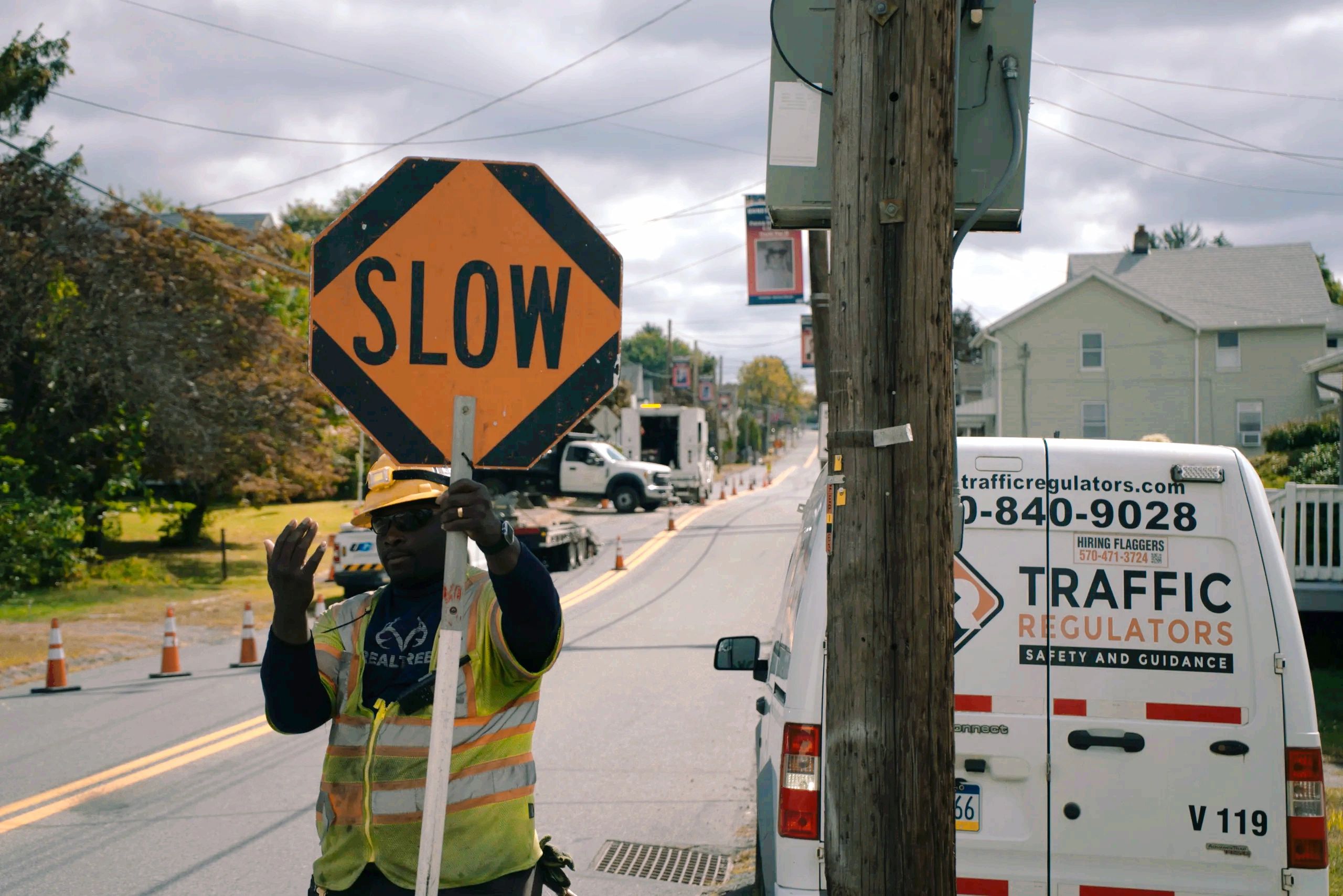 Traffic Regulators flagger directing traffic beside a company vehicle